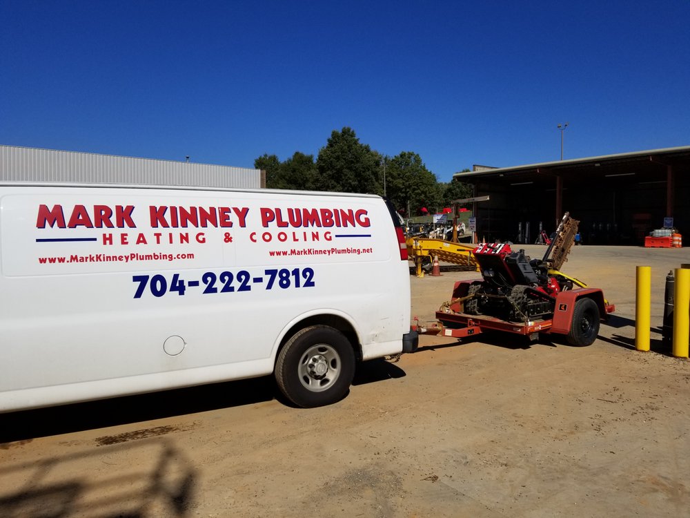 Mark Kinney Plumbing van with equipment at a commercial job site